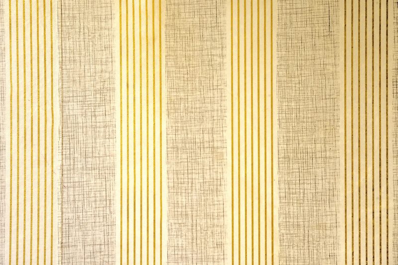 Close-up of a warm gold and cream vertical-striped grasscloth-style wall covering showing its woven texture